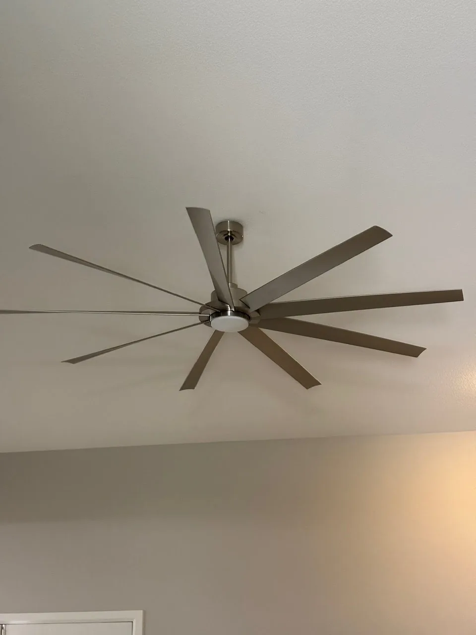 Modern ceiling fan with multiple gray blades and brushed nickel finish mounted on white ceiling.