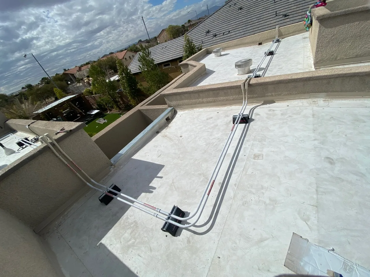Rooftop electrical installation with conduit wiring and junction boxes on a flat roof.